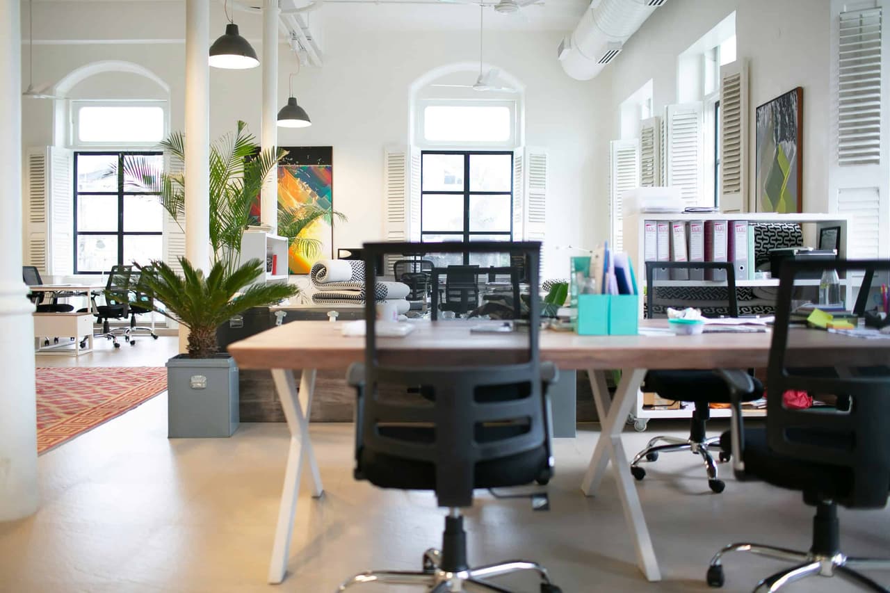 An empty chair facing its back in a shared office space with white lighting
